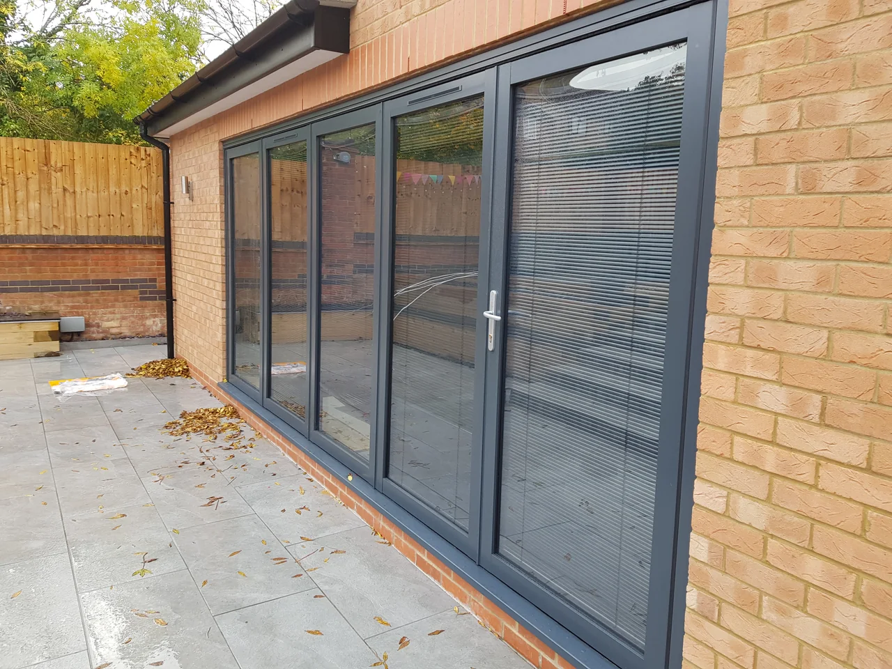 Charcoal OpenGlide doors with integrated blinds visible within the glazing