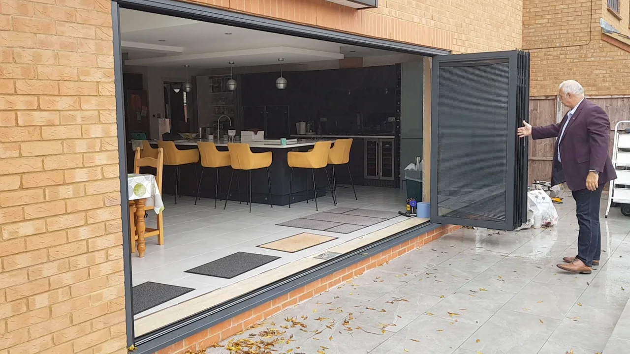 Charcoal OpenGlide doors opening onto a kitchen with yellow bar stools