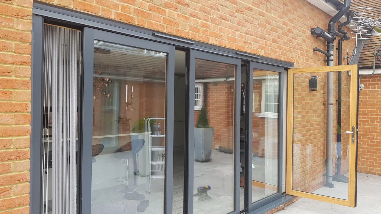 Charcoal exterior OpenGlide frames with a contrasting wood-effect inner face on the open access door