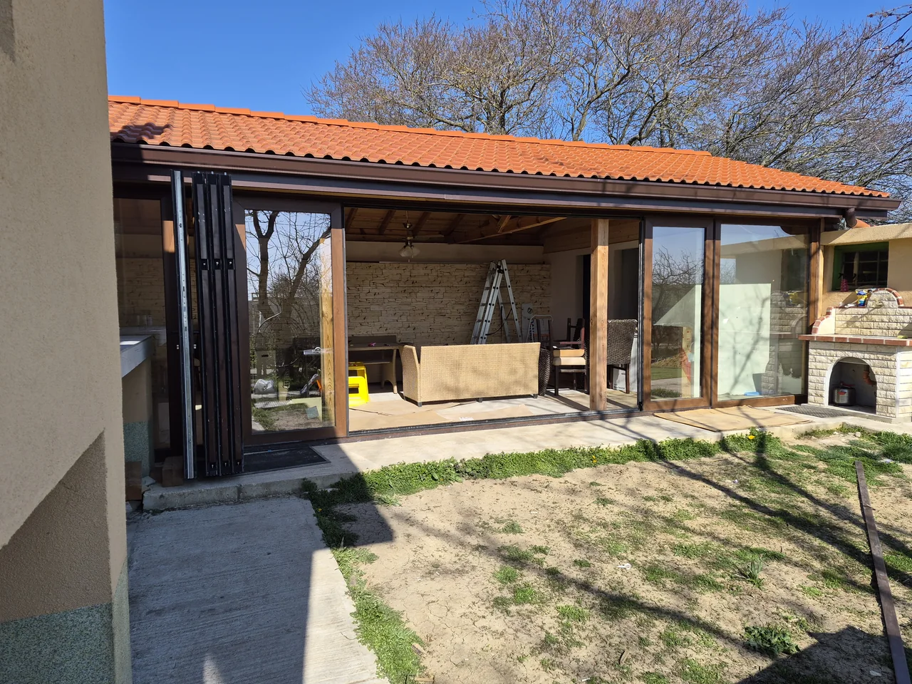 Wood-effect OpenGlide panels gathered beside a wide central opening onto a garden veranda