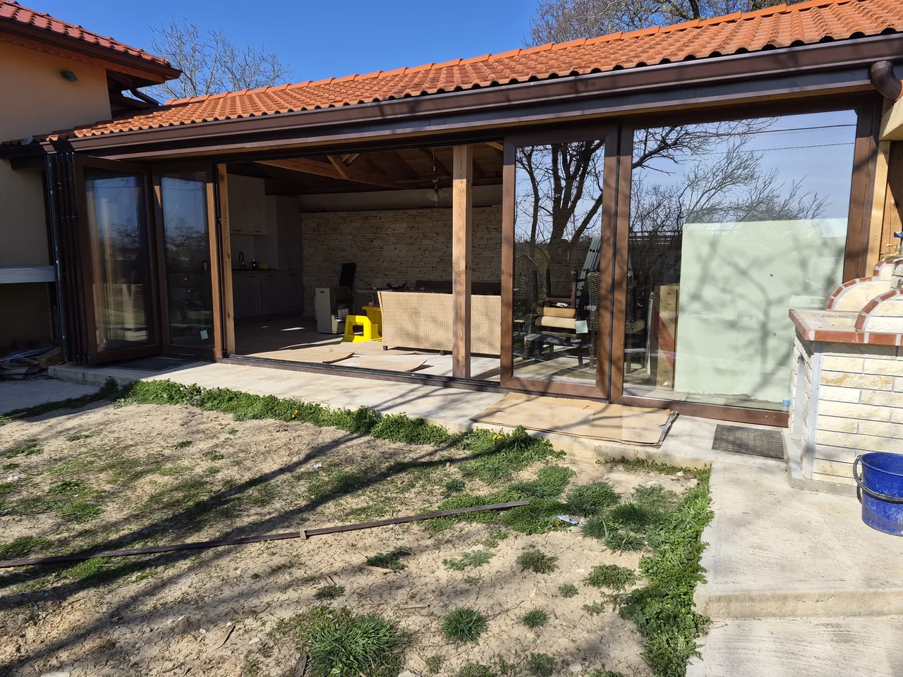 Panels gathered to the left create a broad opening into the veranda.